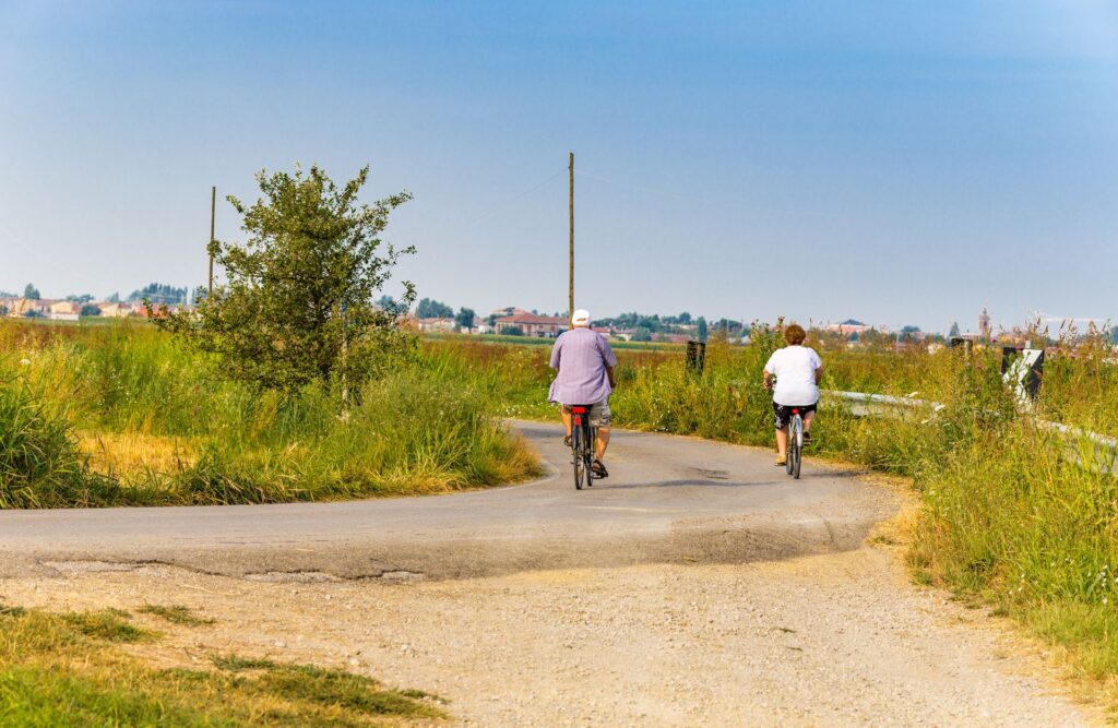 Couple cycling through green countryside