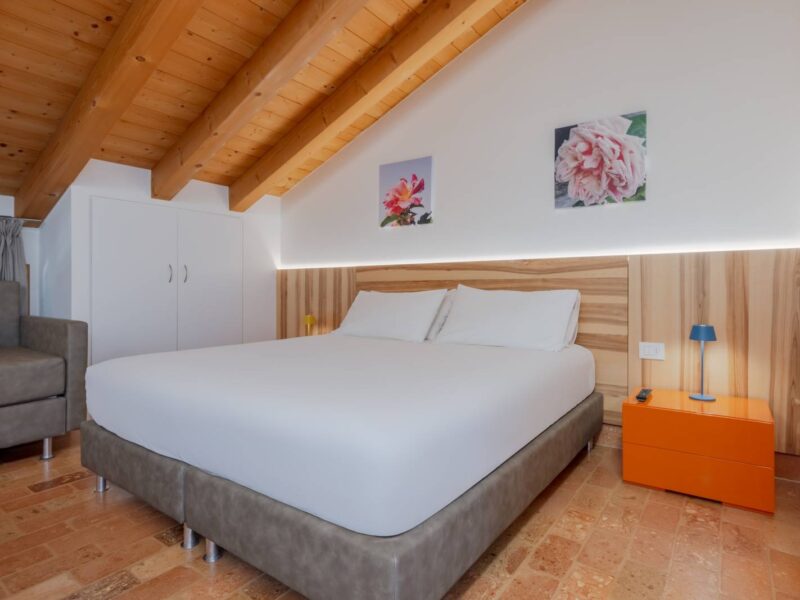 Letto matrimoniale sotto le travi in legno