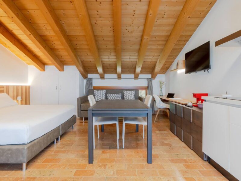 Openspace con letto matrimoniale, tavolo e cucina